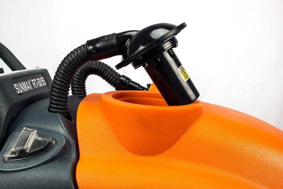Close-up of RT50 battery powered walk-behind floor scrubber with orange tank and black vacuum motor hose